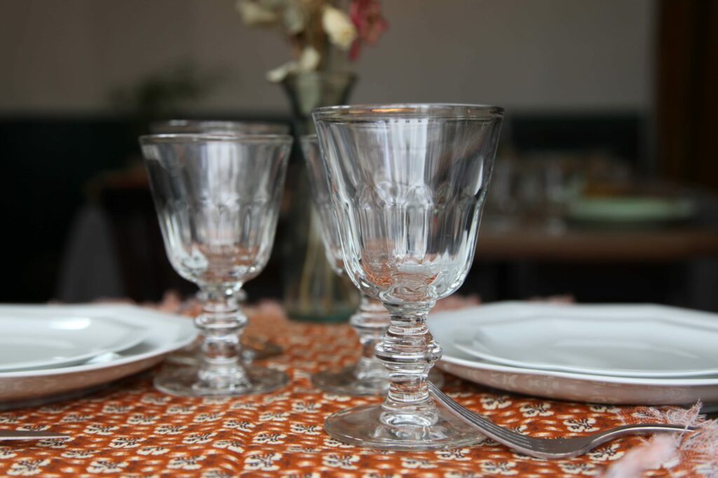 assiette-en-porcelaine-blanche-octogonale-couteaux-opinel-verre-la-rochere-et-tissu-de-la-toile-de-jouy